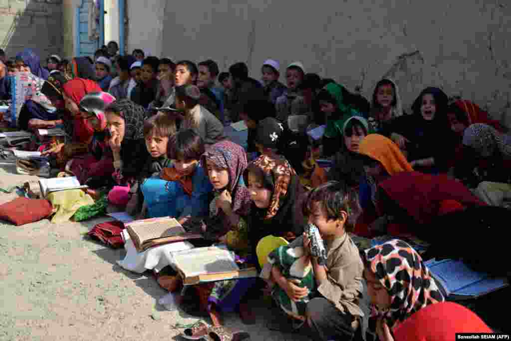 Afghan children study the Koran at an open-air madrasah, or Islamic school, in Kandahar Province.&nbsp;