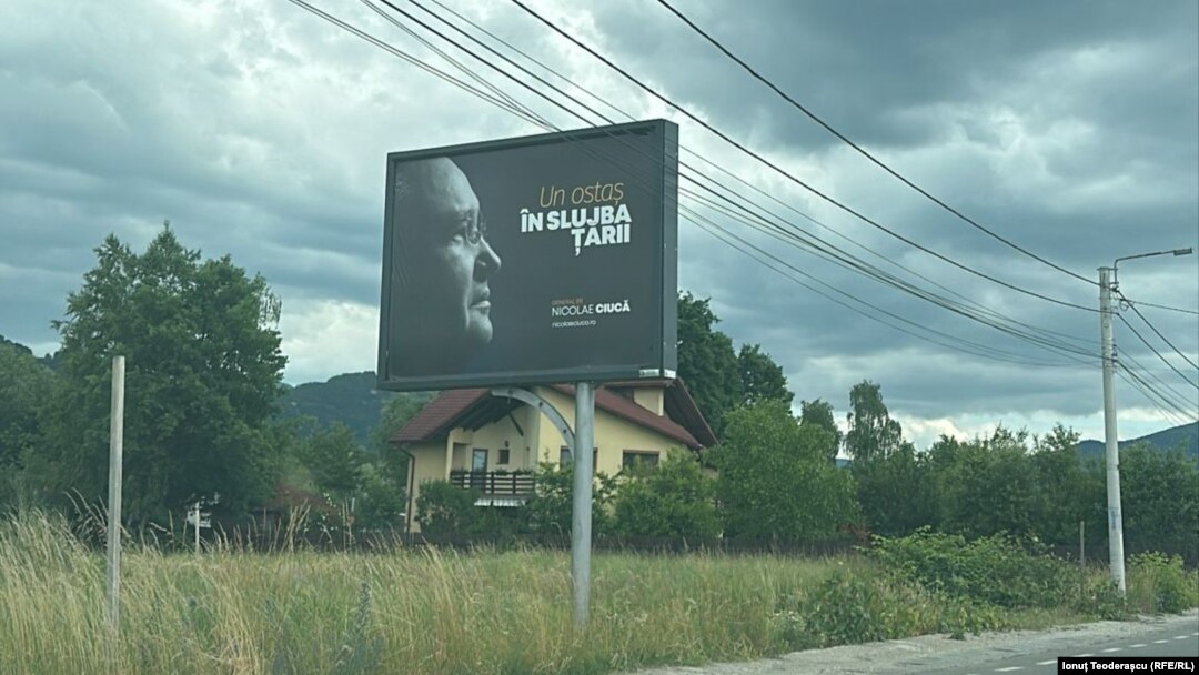 Un afiș cu Nicolae Ciucă în care promovează cartea „Un ostaş în slujba ţării”, pe un drum din Maramureș, 28 mai 2024.