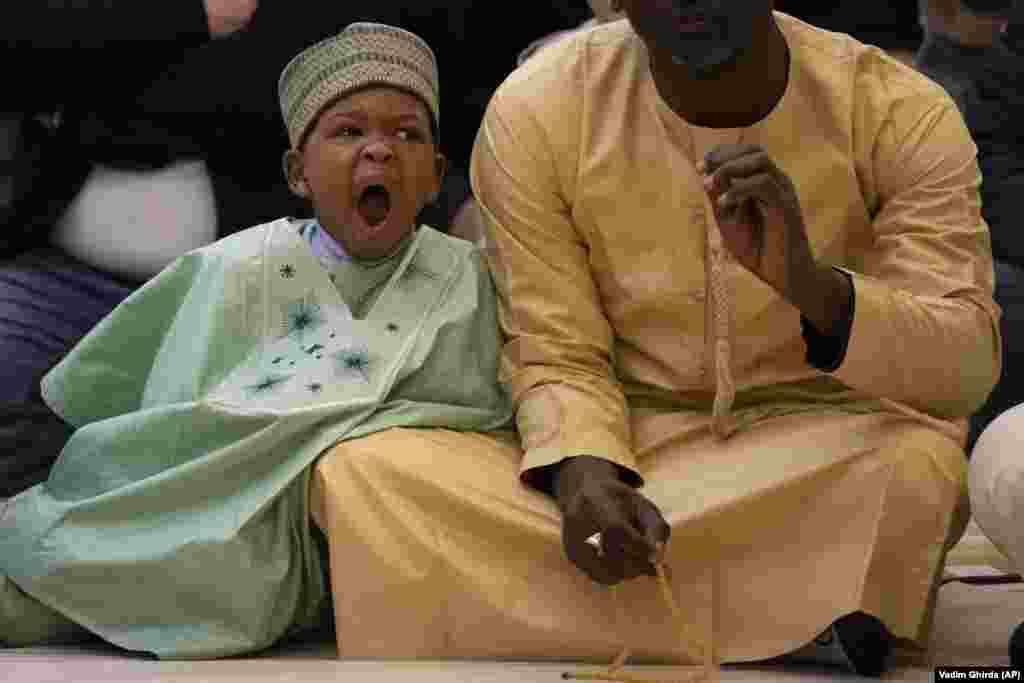 A boy yawns during Eid al-Fitr prayers in Bucharest.