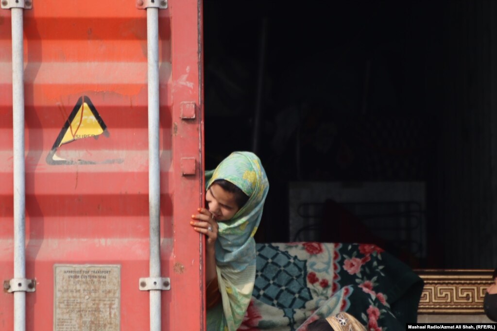 Una giovane ragazza si affaccia dal retro di un container.  Il 3 ottobre, il Ministero degli Interni pakistano ha annunciato che tutti gli immigrati privi di documenti in Pakistan dovevano lasciare il Paese entro 28 giorni.  Al 27 ottobre, circa 60.000 afghani avevano lasciato il Pakistan, hanno riferito le Nazioni Unite.  Molti di loro hanno citato il timore di essere arrestati in Pakistan come motivo principale del ritorno.