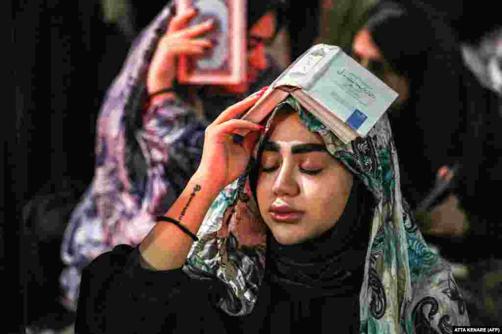 A woman prays during a gathering for the ritual prayers of Laylat al-Qadr (Night of Destiny), one of the holiest nights during the Muslim fasting month of Ramadan, outside the Imamzadeh Saleh Mosque in Tehran.