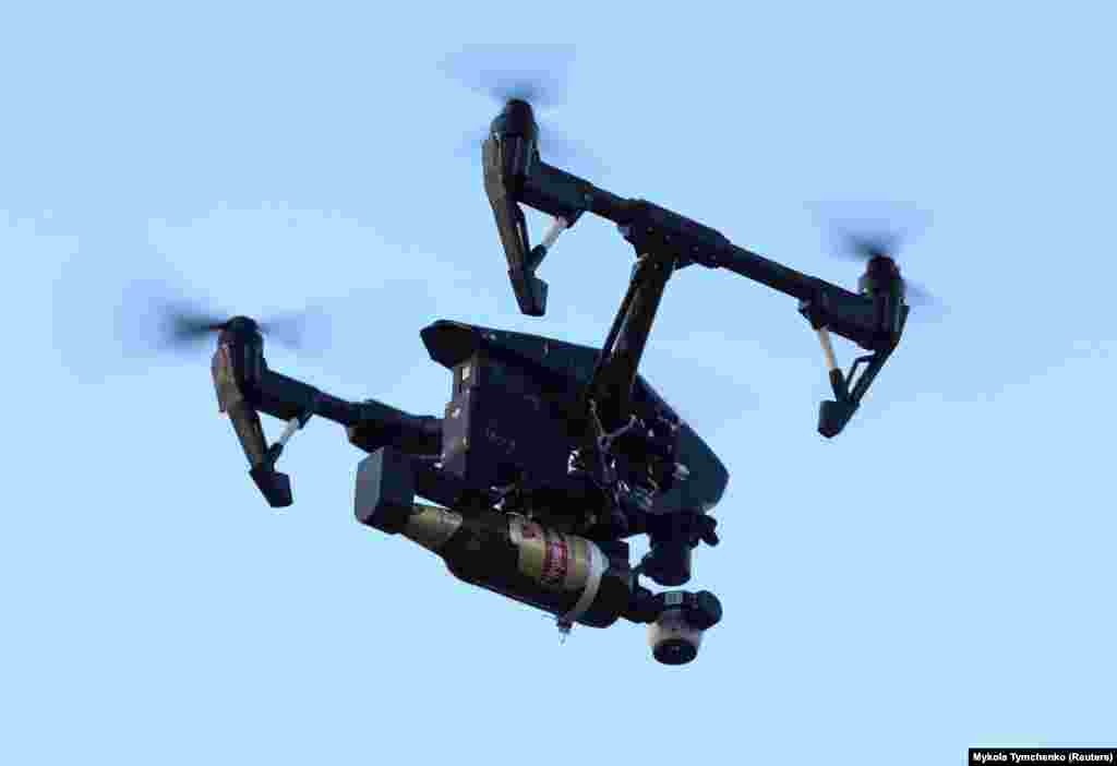 A drone operated by the Ukrainian Territorial Defense Forces is seen in a file photo carrying a Molotov cocktail. The use of drones in the skies above Ukraine is so common that a recent assessment by a British think tank estimates that Kyiv is losing some 10,000 drones every month.