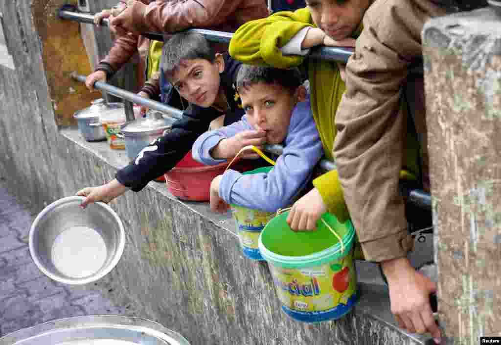 Palestinska djeca čekaju da dobiju kuhanu hranu iz dobrotvorne kuhinje uslijed velike nestašice hrane, Rafa, 20. februar 2024.