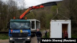 Radnici uz podršku kosovskih policajaca postavljaju kontejnere za glasanje za predstojeće lokalne izbore u Zubinom Potoku, Kosovo, 20. aprila 2023.