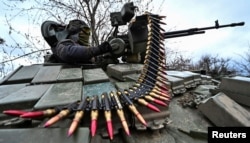 Украинский военнослужащий загружает патроны для пулемета на танке во время военной подготовки у линии фронта в Запорожской области, 29 марта 2023 года