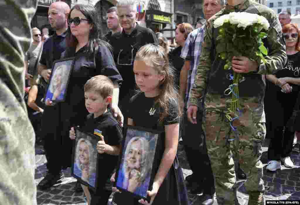 Të afërmit e ish-ligjvënëses ukrainase, Iryna Farion, duke mbajtur portretet e saj, gjatë funeralit të saj, në Lviv, Ukrainë, më 22 korrik. Farion, linguiste dhe politikane nacionaliste, vdiq më 19 korrik, pasi një person i panjohur shtiu me armë zjarri ndaj saj atë ditë, pranë shtëpisë së saj.