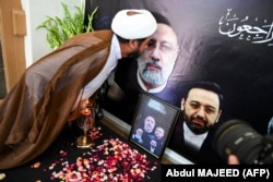 A Pakistani man kisses the portrait of the late Iranian President Ebrahim Raisi, who died in a helicopter crash, during a condolence ceremony held at the Iranian Cultural Center in Peshawar on May 21.