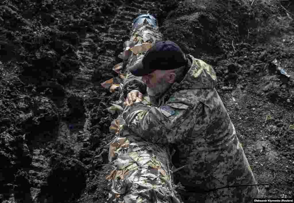 A Ukrainian soldier rests on a tank turret.&nbsp;