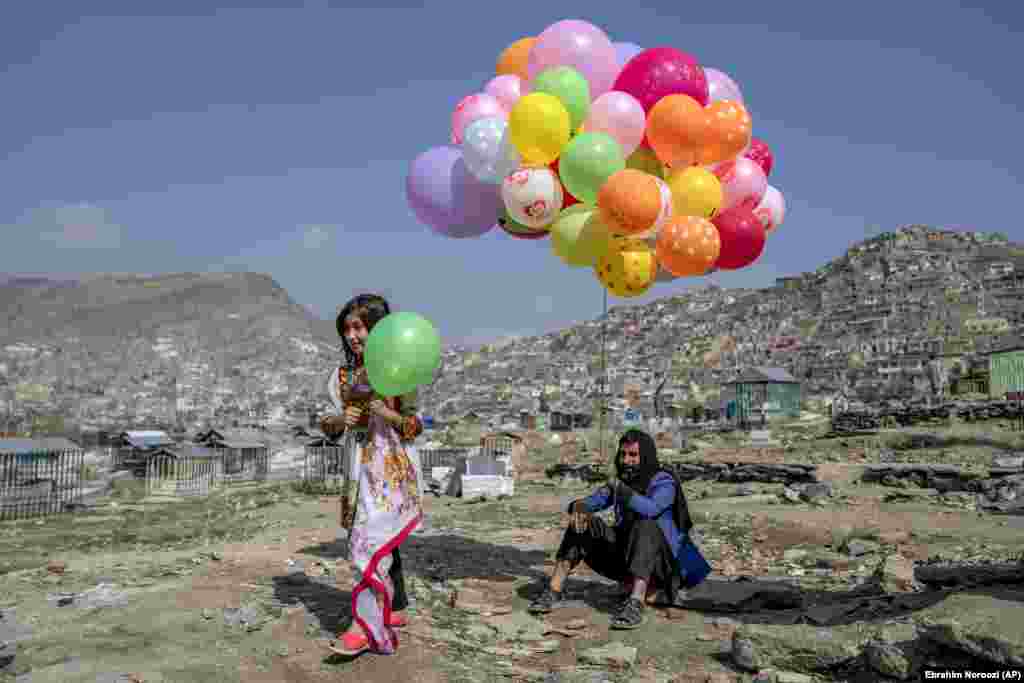 Djevojčica kupuje balon od prodavača balona na dan proslave Novruza u Kabulu, Afganistan, 21. mart 2023.