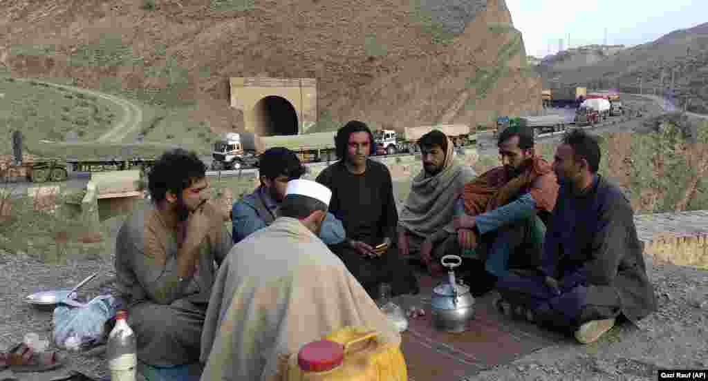 Truck drivers drink tea close to their stranded trucks loaded with supplies for Afghanistan as they wait to for the Torkham border crossing into Pakistan to open after it was closed by the Taliban authorities in Kabul.&nbsp;