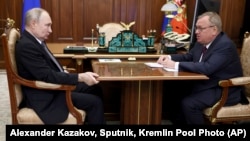 Russian President Vladimir Putin (left) listens to VTB Bank Chairman Andrei Kostin during a meeting in Moscow on July 11, 2023. 