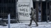 UKRAINE – A Ukrainian soldier walks along a street in Bakhmut, Donetsk region, Ukraine, February 12, 2023. Writing on the wall reads "Bakhmut loves Ukraine"