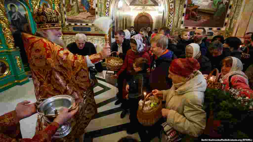 Священник освячує&nbsp;&nbsp;водою вірян під час Великоднього богослужіння УПЦ (МП) у церкві преподобного Агапіта Києво-Печерської лаври