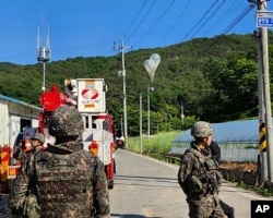 Южнокорейские военнослужащие возле отправленных с территории Северной Кореи "мусорных шаров". Май 2024 года