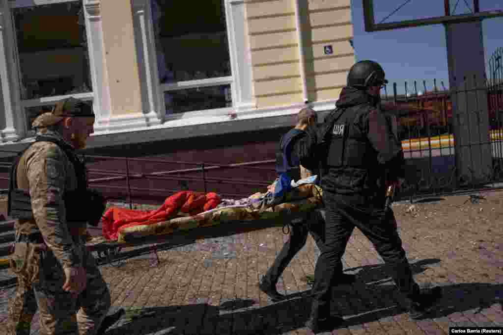 A wounded man is carried away outside the train station.