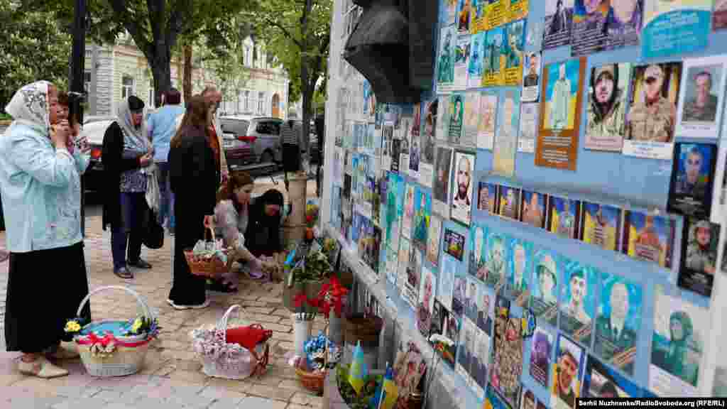 A vallási szertartás után a családtagok megálltak, hogy leróják kegyeletüket Ukrajna elesett védelmezőinek emlékfalánál