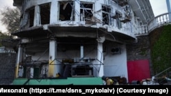 A Ukrainian official examines the aftermath of a strike on a hotel in Mykolaiv on April 28. 