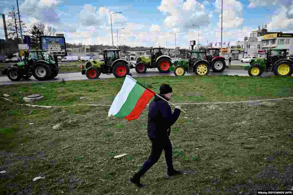 A farmer waves the Bulgarian flag during an action to block trucks crossing the Danube bridge, marking the border between Bulgaria and Romania in a protest against the duty-free import of grain coming from Ukraine into the EU, in Ruse, Bulgaria, on March 29.