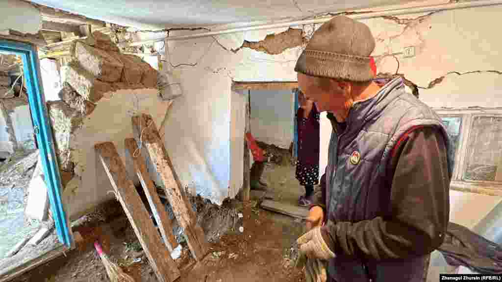 Egy másik karatali, Magyenyijet Eleuov fadeszkákkal támasztja meg az árvíz által megrongált háza részben beomlott falát.&nbsp;A helyiek nemcsak az otthonukat próbálják megmenteni, hanem a megélhetésükhöz szükséges állatállományt is próbálják megtalálni, amelyek közül sok elpusztult az áradás következtében, és most az utcán hever