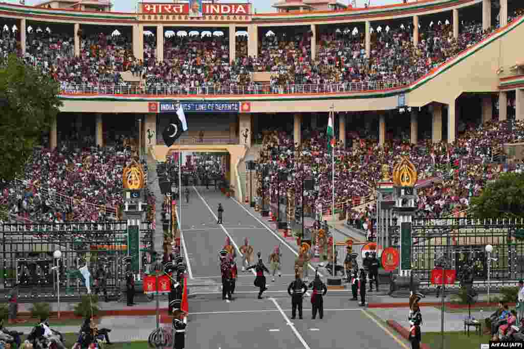 Pakistani Rangers (in black) and Indian Border Security Force (BSF) soldiers take part in the Beating the Retreat ceremony in front of a large crowd on the eve of Independence Day celebrations at the Pakistan-India Wagah border post.