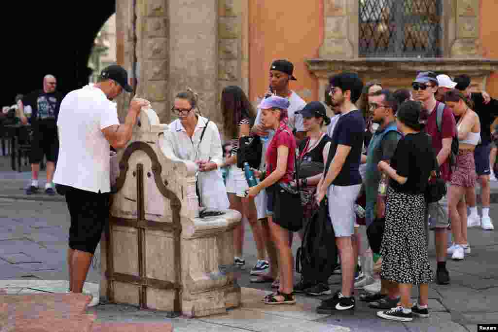 Ljudi čekaju u redu kako bi napunili boce vodom, Bolonja, Italija, 18. juli.