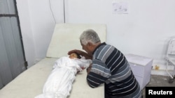 پدری در غزه در کنار پسرش که بر اثر جنگ درگذشته است