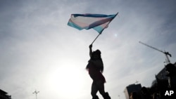 Osoba maše zastavom koja predstavlja transrodnu zajednicu (foto arhiv)