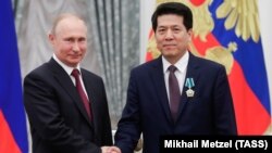 Президент Росії Володимир Путін (ліворуч) і тодішній посол Китаю у РФ Лі Хуей, нагороджений російським орденом Дружби. Москва, Кремль, 23 травня 2019 року
