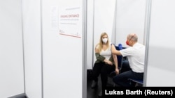 Një grua duke marrë vaksinën kundër COVID-19 në një qendër vaksinimi në Salzburg, Austri, 31 janar 2022.