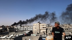 Sűrű fekete füst száll fel egy épületből az izraeli bombázások után a Gázai övezet déli részén fekvő Rafahban 2024. május 10-én