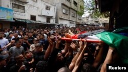 Ožalošćeni prenose tijelo jednog od ubijenih tokom sahrane, Tulkarm, Zapadna obala, 6. maj 2023.