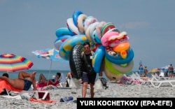 Un georgian vinde jucării gonflabile pe plaja din Batumi, pe 29 iunie.