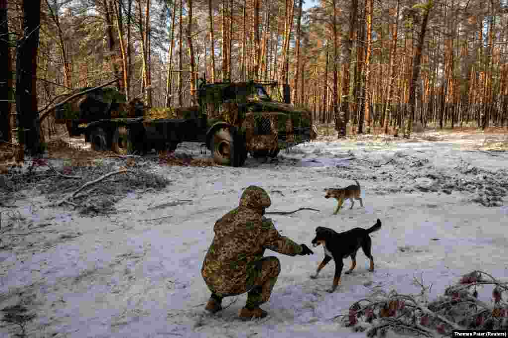 A soldier from Ukraine&#39;s 45th Artillery Brigade feeds a stray dog near the Archer self-propelled howitzer. Brigadier General Oleksandr Tarnavskiy was speaking after Republican lawmakers held up a U.S. aid&nbsp;package and Hungary blocked European Union funding for Kyiv as it battles Russia&#39;s invasion. &nbsp;