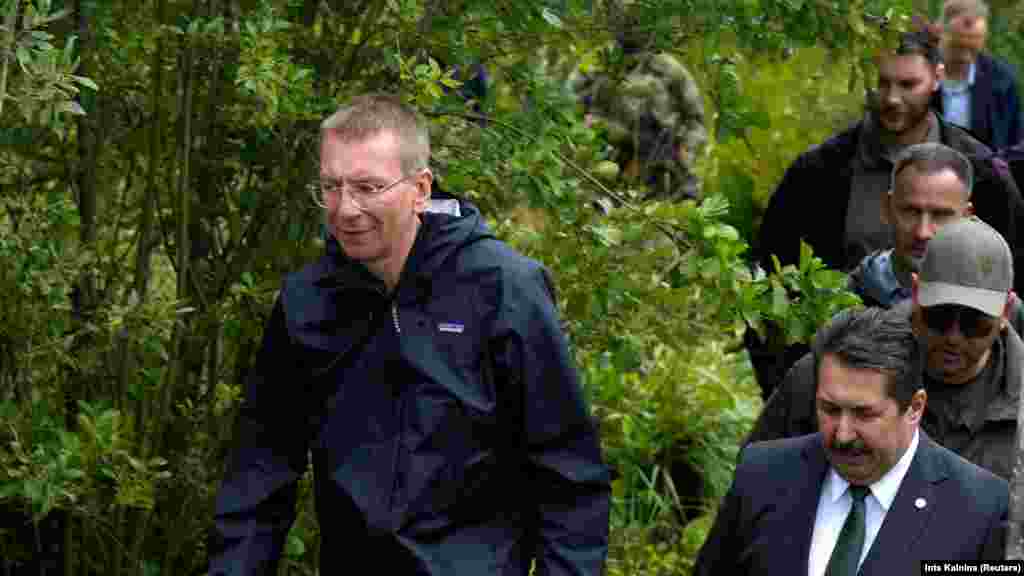 Latvian President Edgars Rinkevics inspects the Latvia-Russia border near Lidumnieki on August 8. The Baltic state has accused its neighboring country and its ruler, Alyaksandr Lukashenka, of deliberately bringing migrants from crisis regions to the border to enter Latvia illegally.