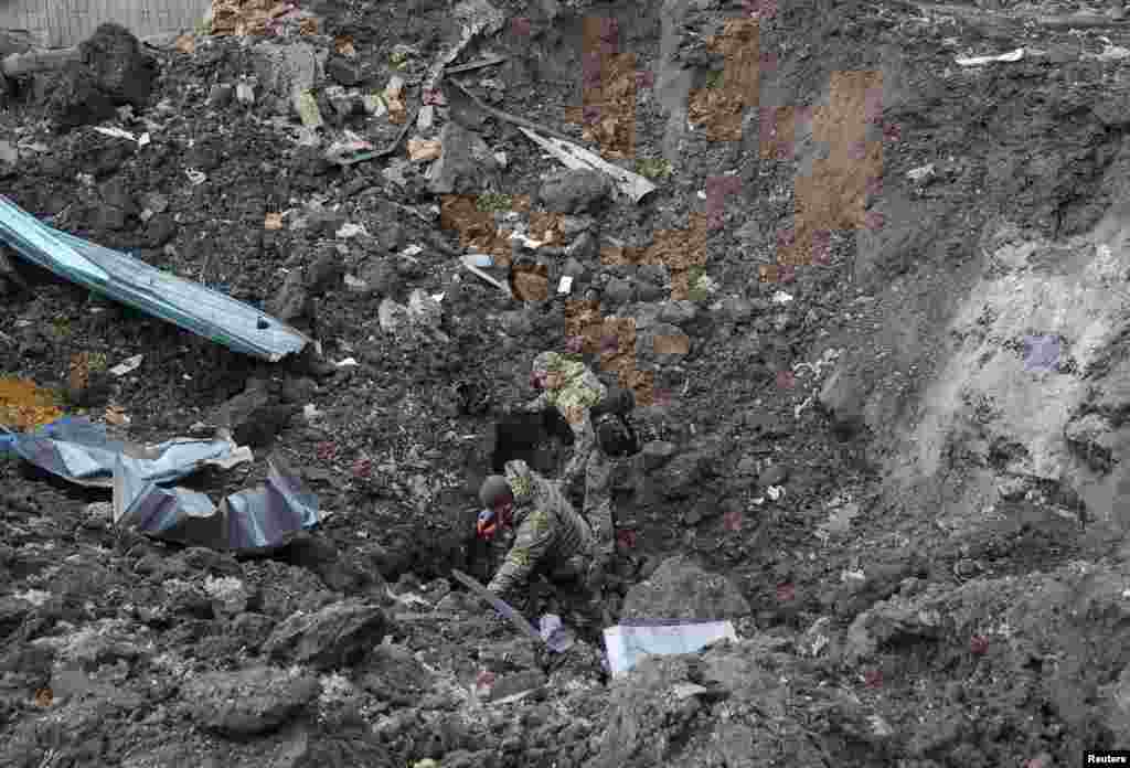 Ukrainian investigators at the bottom of an explosion crater in Kharkiv on January 2.&nbsp; Firing weapons during war provides operational intelligence -- including on how well a missile can evade enemy air defenses -- that is not achievable during normal testing.&nbsp; &nbsp; &nbsp;