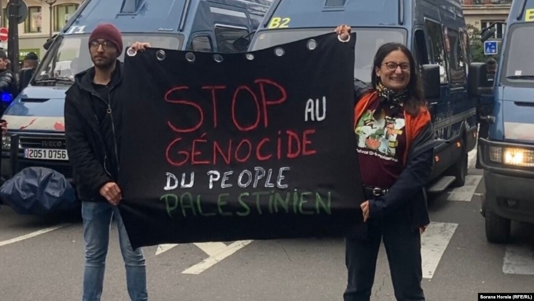 Andreea (dreapta) a fost surprinsă de decizia poliției din Paris de a interzice protestul pentru susținerea Palestinei de la Paris. Alături de un prieten, ea a purtat un banner cu mesajul: „Opriți genocidul poporului palestinian”.
