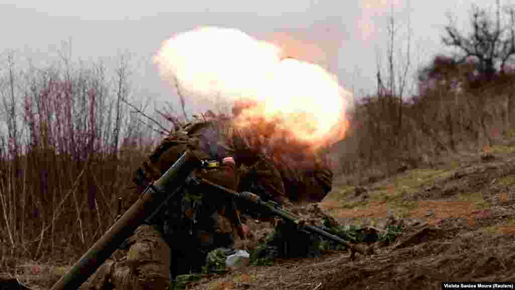 Un soldat ucrainean trage cu mortiera spre pozițiile rusești de lângă Bahmut, pe 16 martie. Trupele Moscovei, în fruntea cărora se află grupul militar privat Wagner, sunt pe punctul să încercuiască trupele ucrainene, însă acestea mențin controlul în partea de vest a orașului din Donbas.