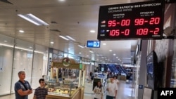 People examine currency rates in front of an exchange office in a Moscow shopping mall late last week. 