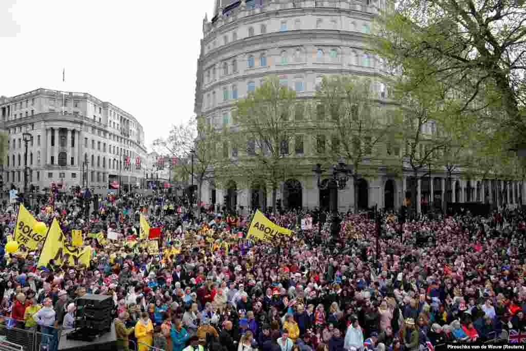 Nézők és tüntetők gyülekeznek, miközben az emberek várják a Buckingham-palotából a Westminster-apátságba tartó koronázási menetet