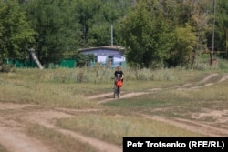 Девочка едет на велосипеде по сельской улице. Село Облавка, Западно-Казахстанская область, 4 августа 2023 года