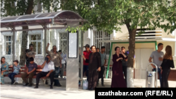 Türkmenistanyň awtobus duralgalarynyň birinde transport serişdesine garaşýan ýolagçylar (Arhiwden alnan illýustrasiýa suraty)