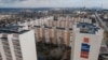 В России пропаганда активно призывает вкладываться в жилье на оккупированных территориях Украины. На фото – новостройки на фоне разрушенного Мариуполя, 2023 год