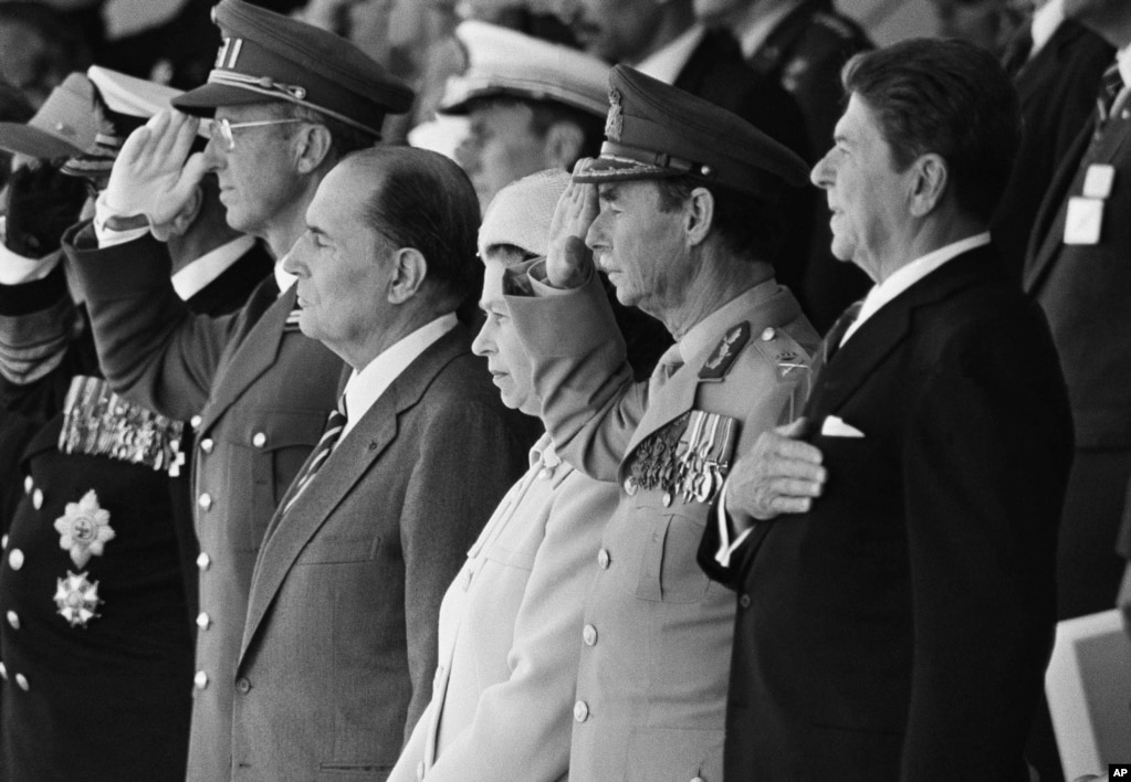 Nga e majta: Mbreti Olav i Norvegjisë (pjesërisht i errësuar) Mbreti Baudouin i Belgjikës, Presidenti francez, Francois Mitterrand, Mbretëresha Elizabeth II e Britanisë, Duka i Madh Zhan i Luksemburgut dhe presidenti i SHBA-së, Ronald Reagan, qëndrojnë në këmbë ndërsa interpretohen himnet gjatë përkujtimeve për 40-vjetorin e Ditës-D, më 6 qershor 1984, në Normandi. Fjalimi i Reganit në Pointe du Hoc ishte menduar jo vetëm si një nderim për heroizmin e njerëzve që zbarkuan në plazhe, por u pa gjithashtu si një deklaratë simbolike që përforcon angazhimin e SHBA-së ndaj parimeve të lirisë dhe demokracisë në sfondin e Luftës së Ftohtë.