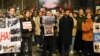 A protester (center) holds images depicting Aleksei Navalny and Russian President Vladimir Putin at demonstration outside the Russian Embassy in Belgrade on February 16, following the news of Navalny's death at an Arctic prison.