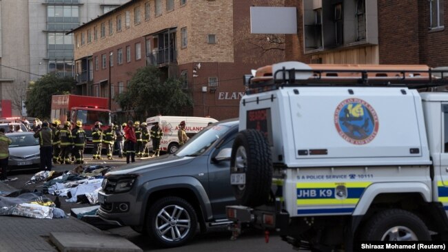 Tijela žrtava poredana su na cesti pored zgrade koje je gorila u centru Johannesburga, 31. avgust