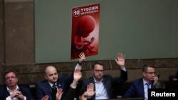 Poslanik stranke Pravo i pravda drži poster tokom glasanja o zakonu o liberalizaciji abortusa u parlamentu u Varšavi, Poljska, 12. aprila 2024.