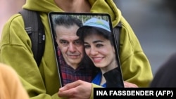 A demonstrator holds a picture of Iranian-German Jamshid Sharmahd (left), who has been sentenced to death in Iran, with his daughter Gazelle Sharmahd, in Berlin on July 31.