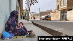 زهرا یکی از زنانی که در هرات در کنار یکی از جاده ها کفش های عابرین را رنگ می کند 