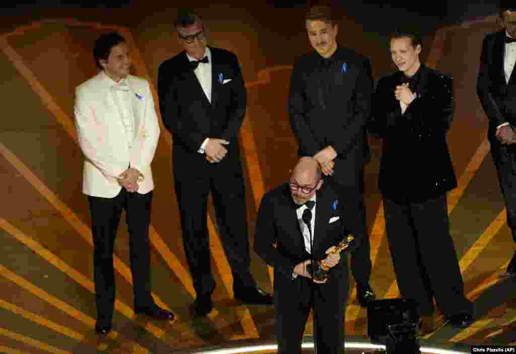 Edward Berger, centar, preuzima nagradu za &quot;All Quiet on the Western Front&quot; iz Njemačke, za najbolji međunarodni igrani film na dodjeli Oscara u nedjelju. Slijeva stoje Daniel Bruhl, Malte Grunert, Albrecht Abraham Schuch i Felix Kammerer.
