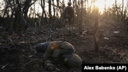 A Ukrainian soldier passes by the body of a dead Russian soldier at the front line a few kilometers from Andriyivka on September 16.